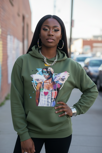 A woman wearing an olive green hoodie with a colorful graphic print of a woman with wings, standing on a city sidewalk with blurred buildings and parked cars in the background.