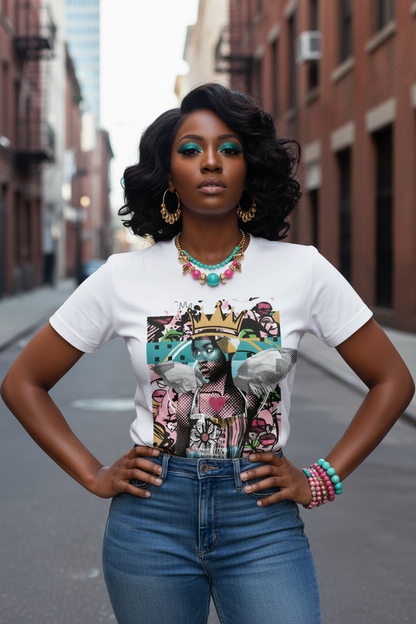 A woman stands in an urban street setting wearing a white graphic T-shirt with a colorful collage print, blue jeans, and layered turquoise and pink jewelry.